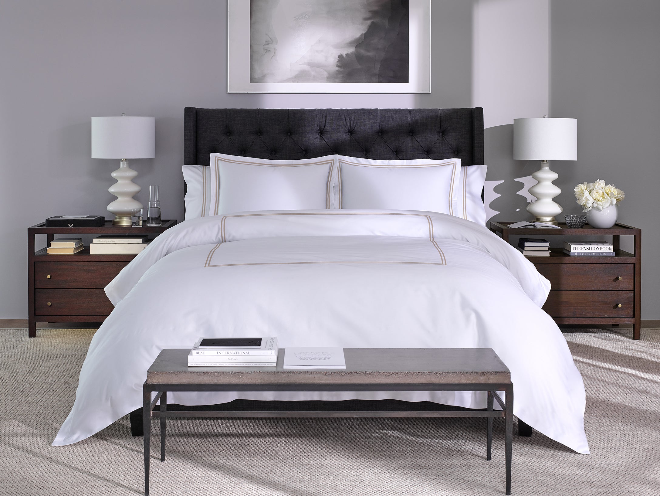 Front view of a white cotton bed sheet with warm taupe stitching on a bed in a modern bedroom, highlighting its elegance, breathable fabric and clean finish